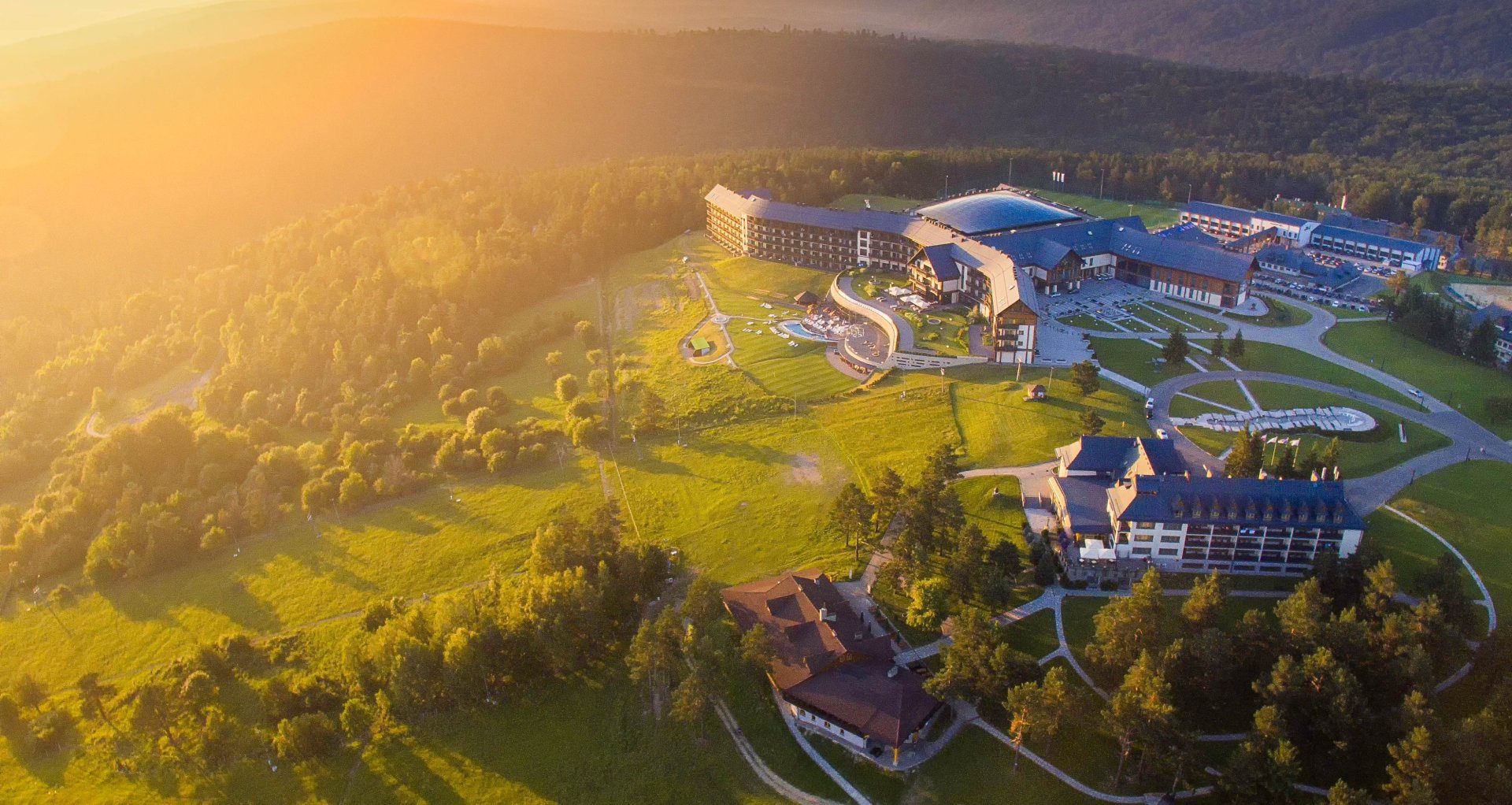 Obraz przedstawia widok na Bieszczadzki Hotel Arłamów wraz z krajobrazem.