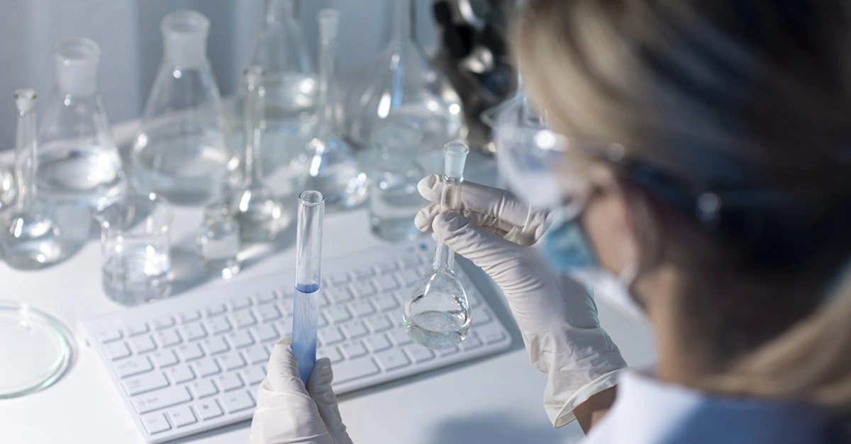 Kobieta w laboratorium z próbkami wody przeprowadzająca badanie.