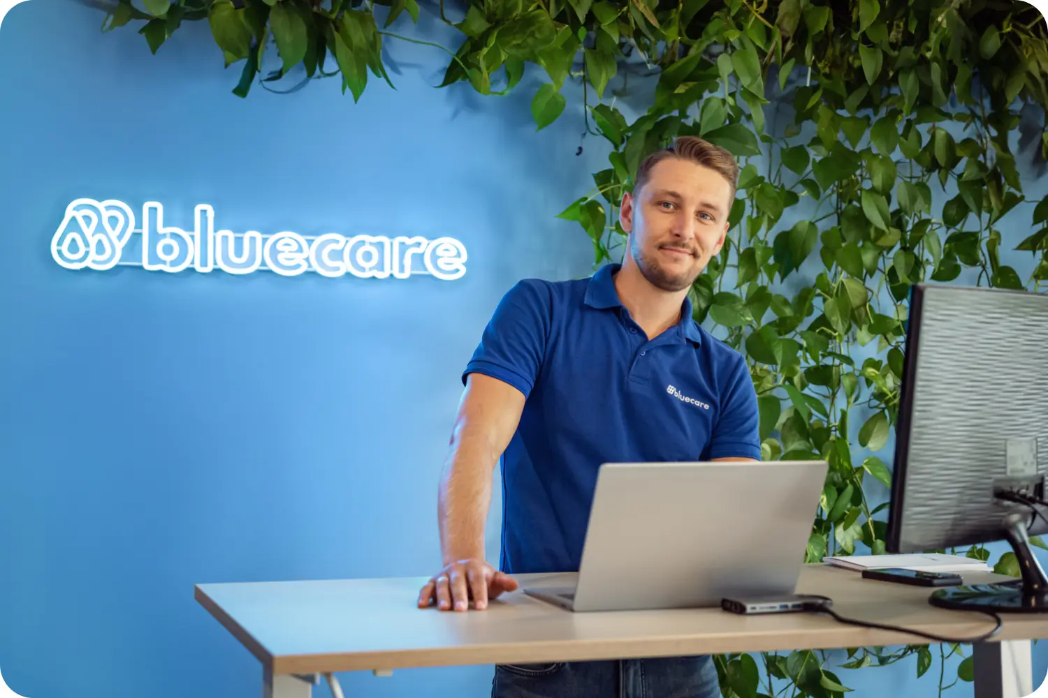 Uśmiechnięty ekspert bluecare przy laptopie, gotowy do omówienia wyników badań wody.